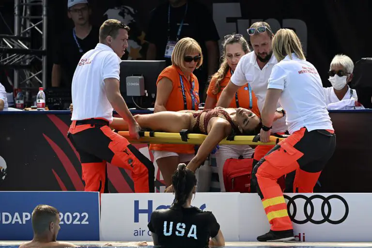 The coach of American swimmer Anita Alvarez saves her as she passes out in the water during the World Championships.